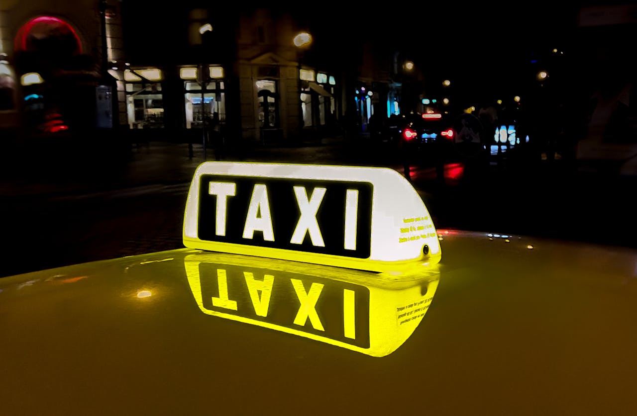 about-01 Close-up of a glowing taxi sign reflecting in the night city street, capturing urban nightlife.